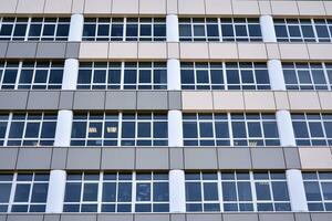 une vue à une tout droit façade de une moderne bâtiment avec une foncé gris façade. foncé gris métallique panneau façade. moderne architectural détails. photo