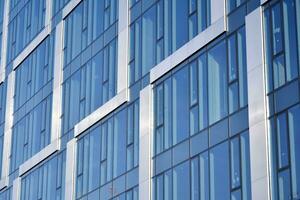 verre bâtiment avec transparent façade de le bâtiment et bleu ciel. de construction verre mur reflétant bleu ciel. abstrait moderne architecture fragment. contemporain architectural Contexte. photo