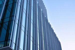 verre bâtiment avec transparent façade de le bâtiment et bleu ciel. de construction verre mur reflétant bleu ciel. abstrait moderne architecture fragment. contemporain architectural Contexte. photo