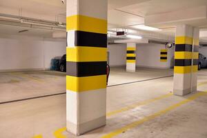 Départ de le souterrain garage avec blanc portail. intérieur piliers peint Jaune. photo