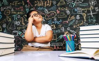 enfant assis et agissant dans la salle de classe photo