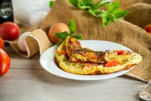 farci omelette avec tomates sur une lumière en bois Contexte. photo