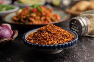 poivre de cayenne sur une assiette sur ciment noir, mise au point sélective. photo