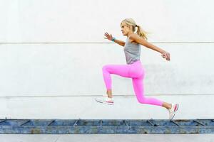 femme dans tenue de sport fonctionnement sur rue dans lumière du jour photo