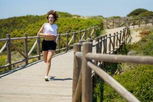 déterminé femme fonctionnement sur en bois chemin dans campagne photo