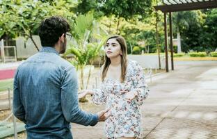 malheureux couple permanent argumenter dans une parc. dégoûté adolescent couple argumenter dans une parc, homme et femme argumenter dans une parc. Jeune couple argumenter malentendu dans une parc photo