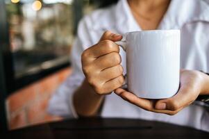 tasse blanche à portée de main pendant le temps de détente photo