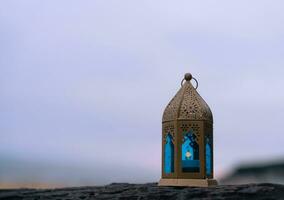 islamique lanterne sur Roche avec floue mer plage fond.eid décoratif traditionnel les lampes illuminé prêt pour le saint saison de Ramadan kareem, aïd Al fitr, aïd Al adha, aïd Moubarak, Muharram photo