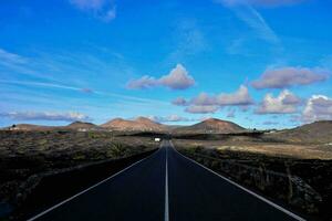 un vide route dans le milieu de une désert avec montagnes dans le Contexte photo