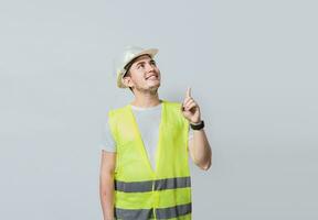 constructeur ingénieur montrer du doigt doigt à le droite isolé, portrait de ingénieur homme montrer du doigt de côté, construction ingénieur avec gilet montrer du doigt à un publicité, ingénieur homme montrer du doigt à côté photo