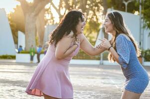 deux content les filles en riant sur le rue, deux femmes parlant et en riant sur le rue, deux femmes ayant amusement photo