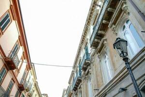 une étroit rue avec une lampe Publier et bâtiments photo