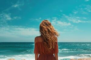 retour vue de Jeune femme dans rouge robe à la recherche à le mer, arrière vue de une femme profiter le vue à le plage ou océan, ai généré photo