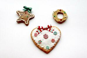 photo de Noël biscuits dans le forme de une cœur, étoile et couronne sur une blanc arrière-plan, fermer