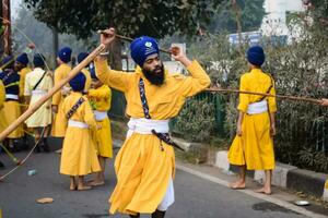 Delhi, Inde, octobre 2, 2023 - sikhs afficher chat et martial les arts pendant annuel Nagar Kirtan, traditionnel, procession sur Compte de anniversaire de gourou nanak dev ji, Nagar kirtan dans est delhi zone photo