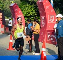 Nouveau Delhi, Inde - octobre 15 2023 - védanta delhi moitié marathon course après convoitise dans lequel marathon les participants à propos à traverser le terminer doubler, delhi moitié marathon 2023 photo