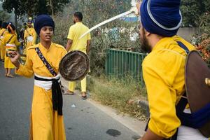 Delhi, Inde, octobre 2, 2023 - sikhs afficher chat et martial les arts pendant annuel Nagar Kirtan, traditionnel, procession sur Compte de anniversaire de gourou nanak dev ji, Nagar kirtan dans est delhi zone photo