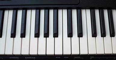 fermer de piano clés. piano noir et blanc clés et piano clavier musical instrument mis à le Accueil balcon pendant ensoleillé journée. photo