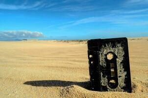 une cassette est séance dans le le sable sur une désert photo