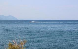 paysage marin avec des montagnes et des gens sur un jet ski photo