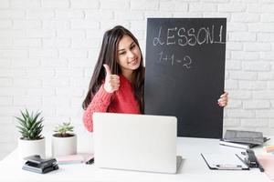 jeune femme latine dans des écouteurs noirs enseignant l'anglais en ligne photo