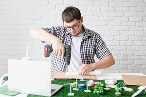 jeune homme enseignant en ligne faisant un mannequin d'énergie renouvelable