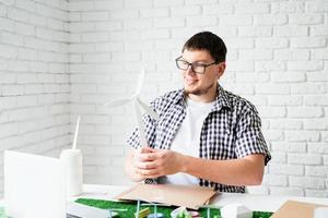 jeune homme enseignant en ligne faisant un mannequin d'énergie renouvelable