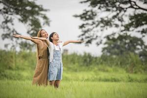 mère et fille debout heureux dans le champ d'herbe photo