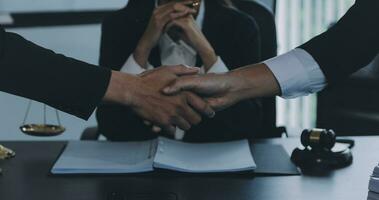 homme d'affaires se serrant la main pour sceller un accord avec ses avocats partenaires ou avocats discutant d'un accord contractuel photo