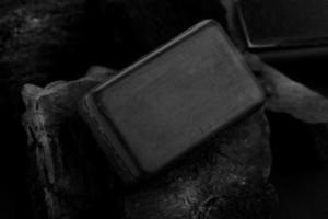 barre de savon au charbon de bois noir sur fond de charbon noir photo