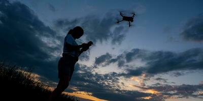 silhouette de femme contrôler drone sur le coucher du soleil Contexte photo
