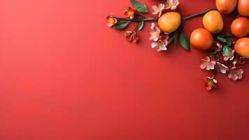 Orange fleurs et fruit contre une audacieux rouge Contexte photo