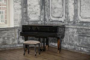 un vieux piano à queue rétro se dresse dans la pièce. photo