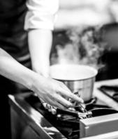 chef cuisinant dans une cuisine, chef au travail, noir et blanc photo