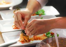 chef cuisinant, chef préparant la nourriture, chef décorant un plat dans la cuisine photo