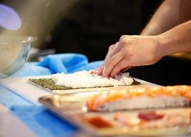 mains de chef préparant la nourriture japonaise, chef faisant des sushis