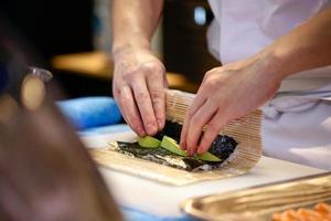 mains de chef préparant la nourriture japonaise, chef faisant des sushis