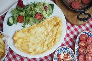 omelette avec légume salade dans blanc assiette sur table photo