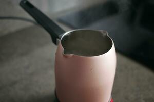 chaud l'eau dans une pot sur table photo