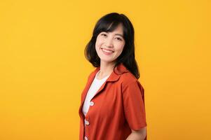 portrait Jeune magnifique asiatique femme content sourire habillé dans Orange vêtements isolé sur Jaune studio Contexte. asiatique fille Humain affronter. photo