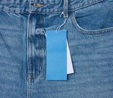 papier prix étiquette sur une corde lié à le ceinture de bleu jeans photo