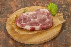 steak de porc cru sur planche de bois photo