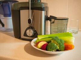 presse-agrumes avec assiette de Frais des légumes photo