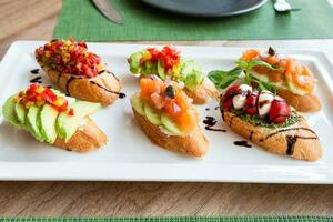 assorti Bruschetta avec apéritifs sur blanc assiette photo