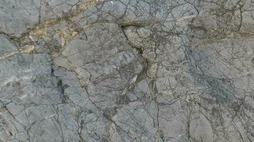 une proche en haut de une Roche avec des fissures et des fissures photo