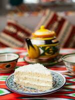 dessert Lait fille avec blanc crème et noix de coco dans Oriental style sur une toit avec une théière et une tasse pour thé. photo