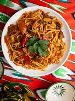 le Oriental lagman plat est fait maison nouilles frit avec Viande, des légumes et herbes. est cuisine photo