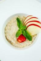 Pomme bouillie avec menthe et des fraises dans une blanc plaque, Haut vue photo