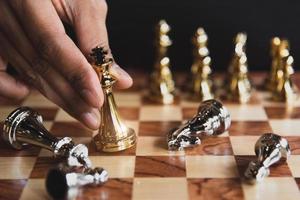 figure d'échecs dorée en mouvement à la main éliminant dans une compétition de combat photo