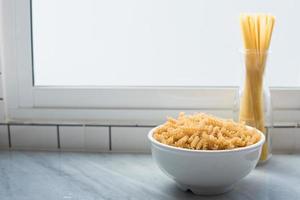 bol blanc de macaronis en spirale et de spaghettis attachés debout photo